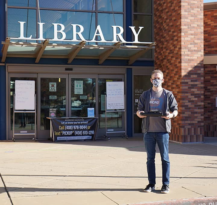 Man standing outside of a library branch.