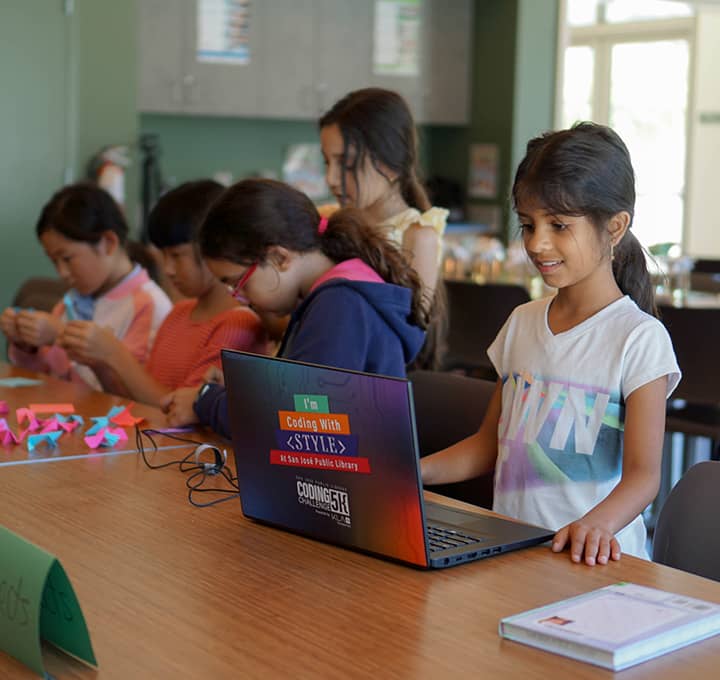 Young girl on a laptop at a program event.
