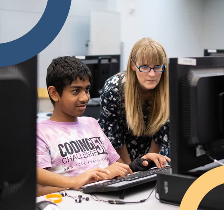 Student and tutor working together during a coding event.