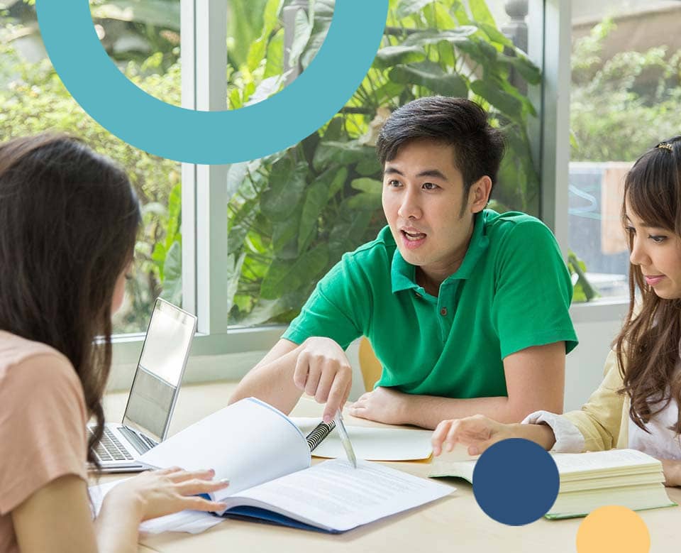 Teens at the library discussing study work.