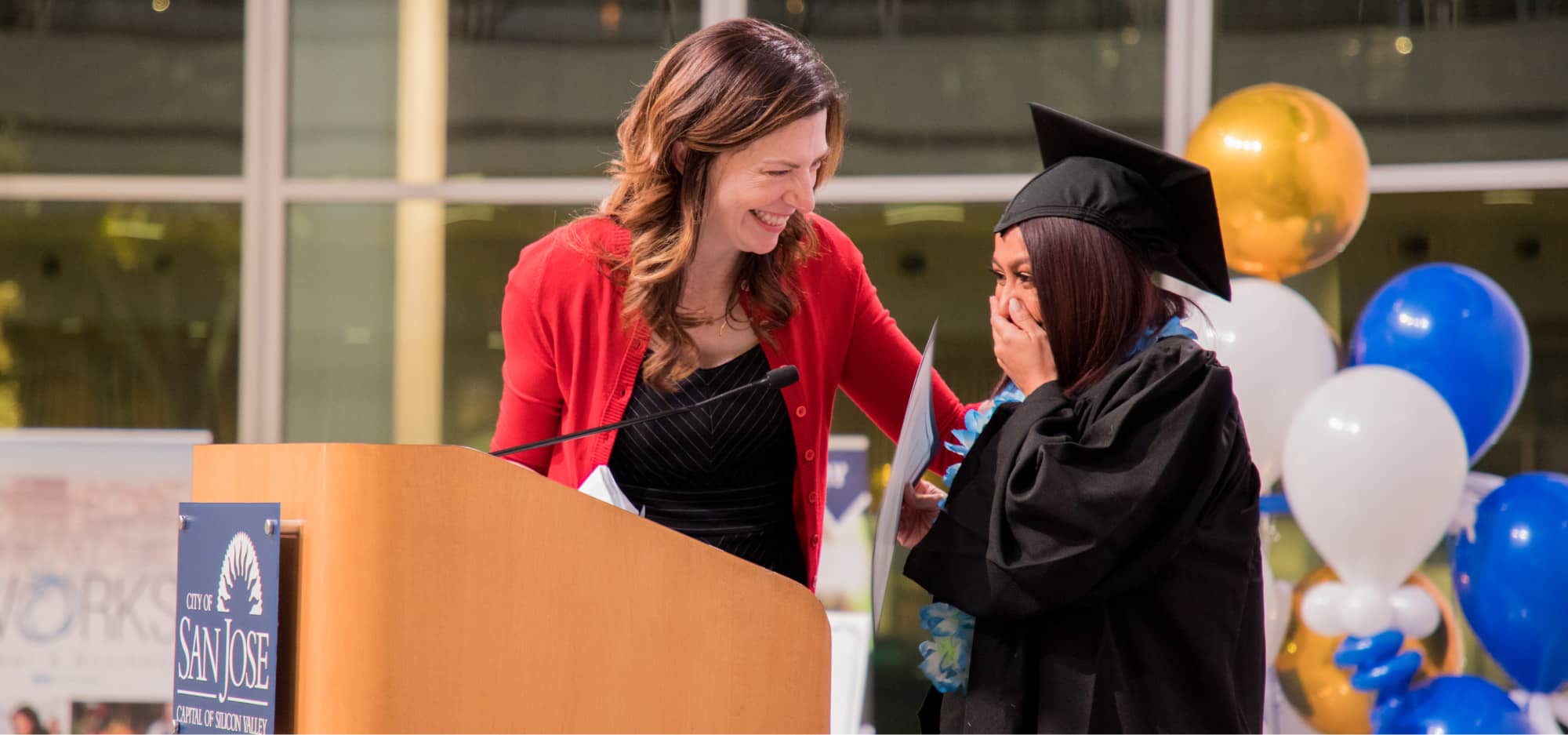 Graduate and presenter at commencement ceremony.