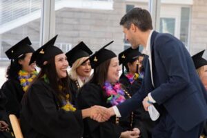 A career online high school graduate shakes hands with Mayor Matt Mahan.