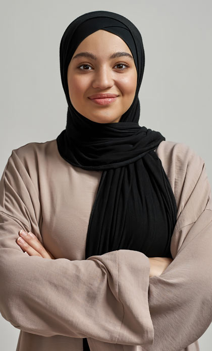 An adult library patron in a hijab smiling.