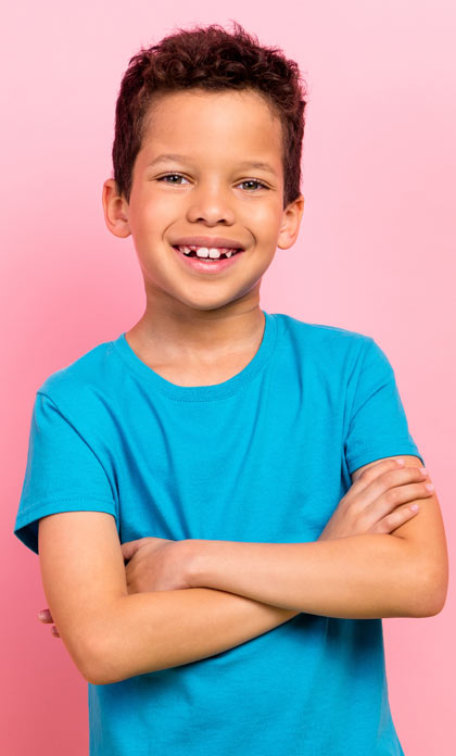 A young library patron smiling with his arms crossed.